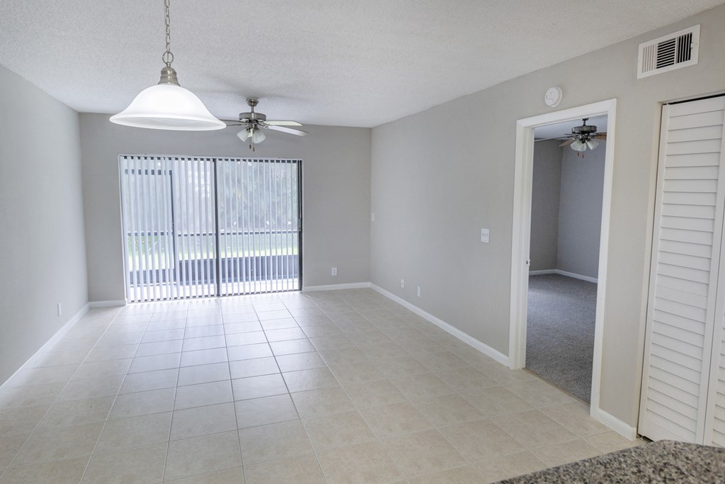 A room with a ceiling fan and a window with blinds.